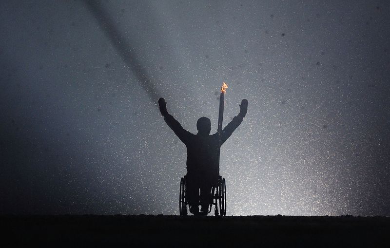 Рик Хансен везет Олимпийский огонь на церемонии открытия Зимних Олимпийских игр 2010 в Ванкувере.