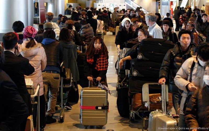 9. Пассажиры в очереди на регистрацию в аэропорту Нарита, Токио.