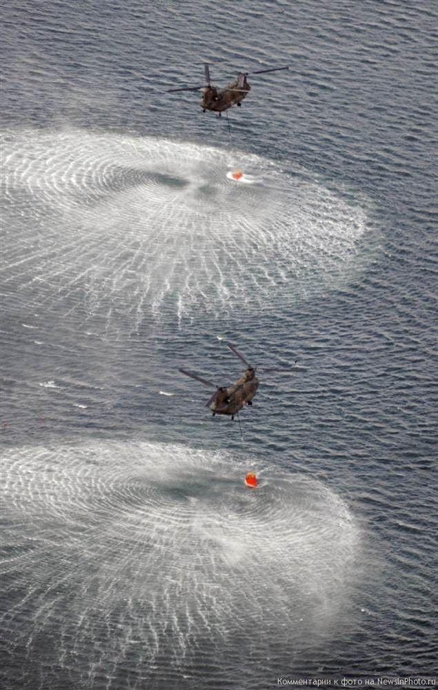 18. Вертолеты сил самообороны Японии набирают воду на северо-восточном побережье Японии по пути к атомной станции Фукусима Дай-ити в Окумамати