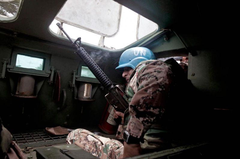 Миротворец ООН из иорданского батальона перезаряжает оружие во время перестрелки со сторонниками Гбагбо на улицах Абиджана.