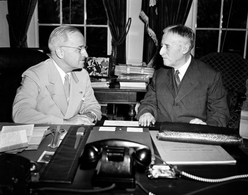 Президент Гарри Трумэн (на фотографии слева) за своим столом в Белом доме рядом с военным министром Генри Л.Стимсоном после возвращения с Потсдамской конференции. Они обсуждают атомную бомбу, сброшенную на Хиросиму, Япония.