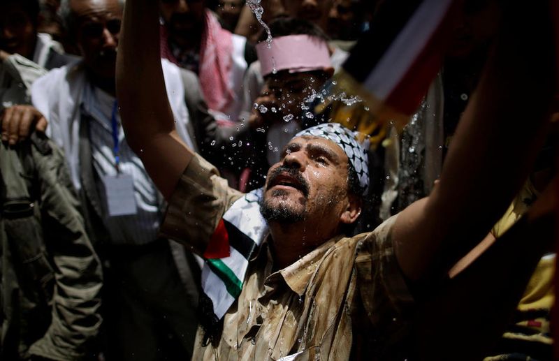 Демонстрант освежается водой во время демонстрации против президента Али Абдуллы Салеха. (AP Photo/Muhammed Muheisen)