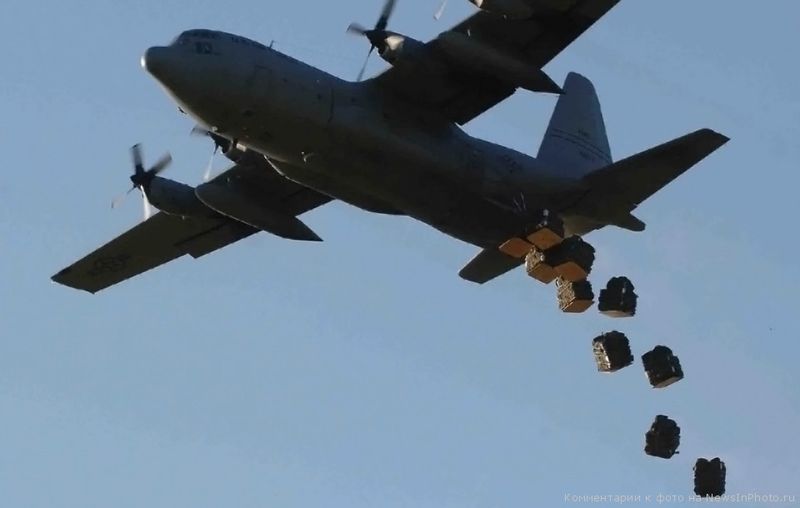 9. Самолет ВВС США «Геркулес С-130» сбрасывает тюки со складными палатками и противомоскитными сетками на поле у Дадааба, Кения. 10 декабря 2006 года. Летчики США помогли доставить гуманитарную помощь примерно 160 000 пострадавшим от наводнения в сельских районах Кении.