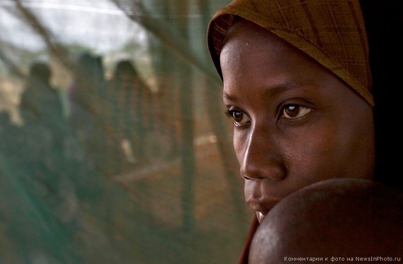 12. Беженка из Сомали с ребенком в ожидании распределения пищи в медпункте благотворительной медицинской миссии Médecins Sans Frontières («Врачи без границ») в лагере Дагахали, Дадааб, северо-восточная провинция Кении. 7 июня 2009 года.