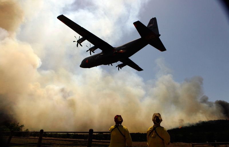 Самолет-заправщик над пожарными недалеко от Поссум Кингдом 19 апреля. (AP Photo/LM Otero)