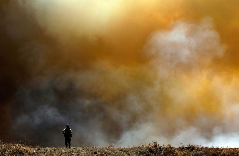 Пожарный округа Сан-Диего Джейсон Лэмберт на фоне дыма от пожара в Строуне 19 апреля. (Tom Pennington/Getty Images)