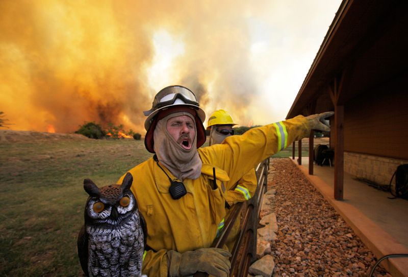 . Пожарный Крейг Говард раздает приказы по спасению дома от пожара недалеко от Поссум Кингдом. (AP Photo/LM Otero)