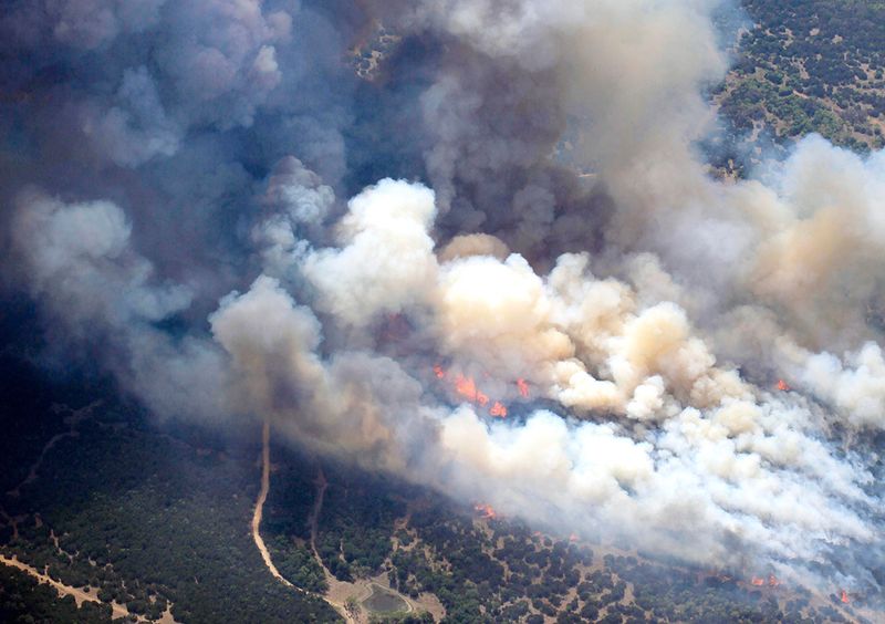 Новые лесные пожары недалеко от озера Поссум Кингдом, где были уничтожены дома на территории до 112 км к западу от Форт Ворт, 19 апреля. Это уже пятый пожар в Техасе, уничтоживший более 40 тысяч гектаров леса за последние две недели. (AP Photo/The Dallas Morning News, David Woo)