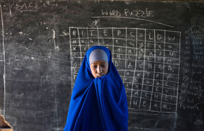 26. Юная сомалийка стоит возле доски в одной из классных комнат лагеря для беженцев Хагадера в Дадаабе 4 июня 2009 года. (Reuters/Finbarr O'Reilly)