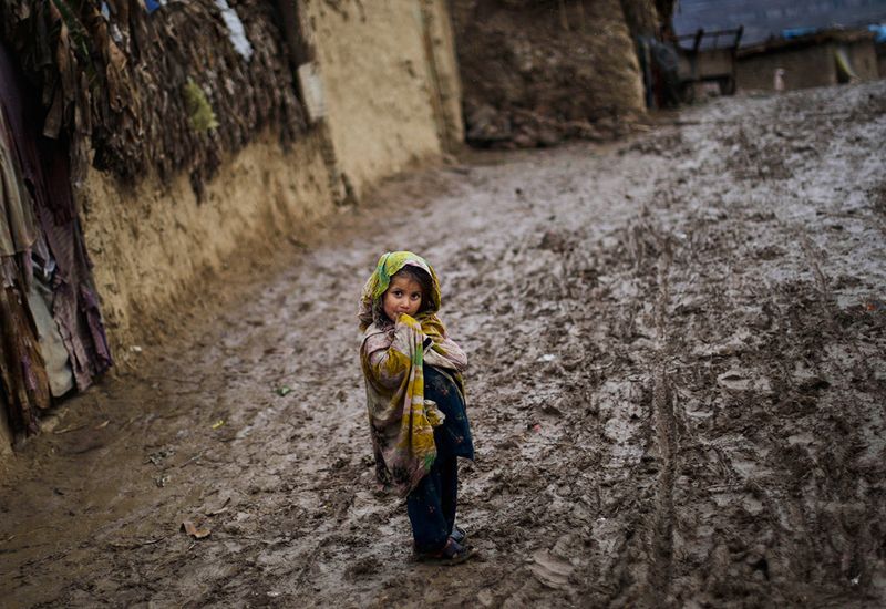 Пакистанская девочка в пасмурный день на грязной дороге в трущобах на окраине Исламабада. (AP Photo/Muhammed Muheisen)