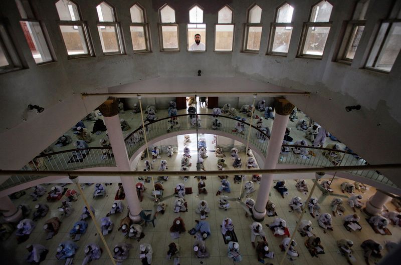 Охранник на крыше во время религиозного экзамена студентов в семинарии в Карачи. Около 2300 студентов приняли участие в экзамене. (Reuters/Athar Hussain)