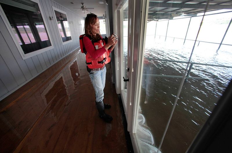 Владелица склада и дока в Видали Карла Дженкинс фотографирует поднимающиеся воды реки Миссисипи из своего офиса. (AP Photo/Gerald Herbert)