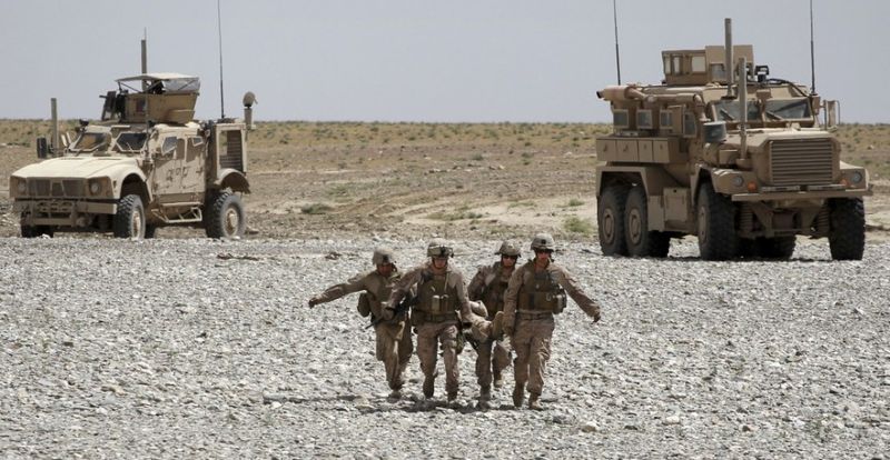  Раненного во время взрыва морского пехотинца переносят в санитарный вертолет Целевой группы армии США “Dust Off,” 1-214 авиационного полка в районе Сангин в провинции Гильменд на юге Афганистана, воскресенье, 8 мая 2011 года.