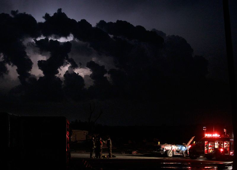  Спасатели ждут медиков после обнаружения тела в поврежденном торнадо автомобиле в Джоплине. (Charlie Riedel/AP)