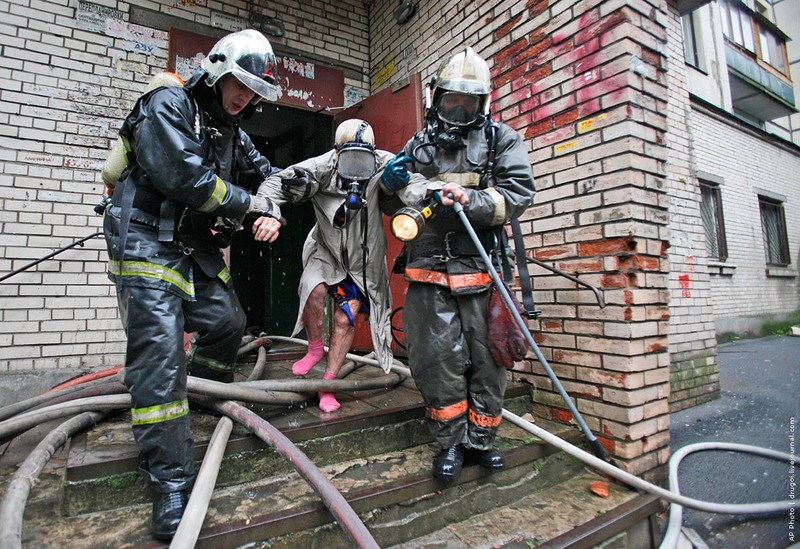 18.06.2009, Россия | Пожарные выводят из здания пострадавшего после взрыва бытового газа и пожара в жилом доме.