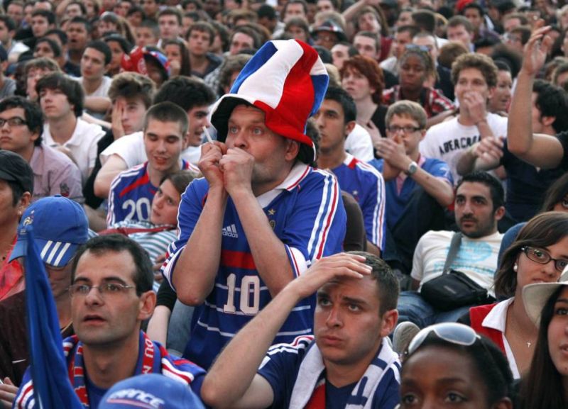 Французские фанаты реагируют на игру из сборной против Уругвая. Футбольные болельщики собрались перед огромным экраном недалеко от Эйфелевой башни 11 июня, чтобы посмотреть мачт, закончившийся ничьей (0-0).