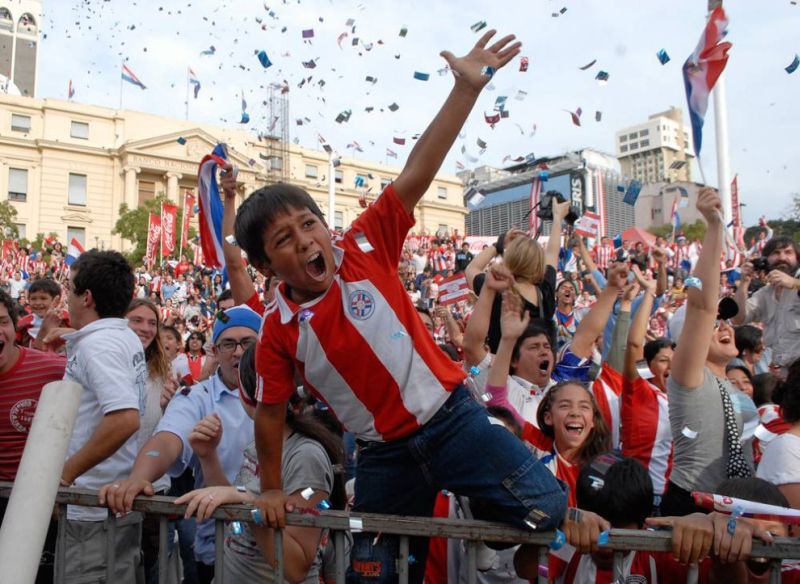 Парагвайцы празднуют гол Антолина Алкараза в ворота сборной Италии в Асунсьоне, одном из старейших городов Парагвая.