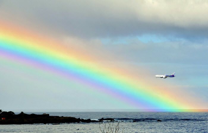 Самолёт пролетает около радуги, раскинувшейся над заливом острова Пасхи, 3 700 км от побережья Чили в Тихом океане, 12 июля 2010 года. (MARTIN BERNETTI/AFP/Getty Images)
