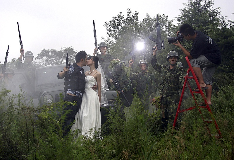 Фотограф снимает будущих молодоженов в Нанкине, Китай, среда. Молодожены собираются праздновать свадьбу в военном стиле. В Китае модно фотографироваться перед свадьбой. (Associated Press)