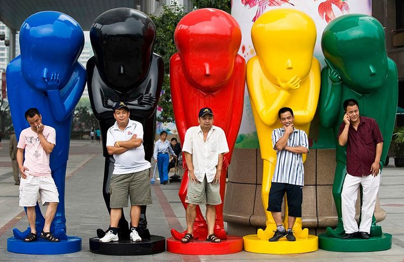 36) Китайцы позируют фотографу на статуях возле торгового центра в Пекине, Китай, 30 июля. (Andy Wong, AP)