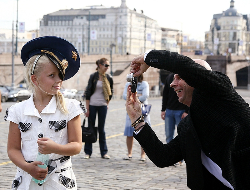 Миллиардер Ги Лалиберте фотографирует Арину, дочь российского космонавта Максима Сураева, на Красной площади в Москве. Г-н Лалиберте, владелец знаменитого «Cirque Du Soleil» станет первым космическим туристом из Канады.