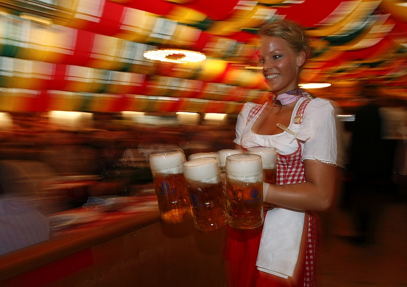 Официантка несет кружки с пивом во время фестиваля Октоберфест в Берлине в среду.