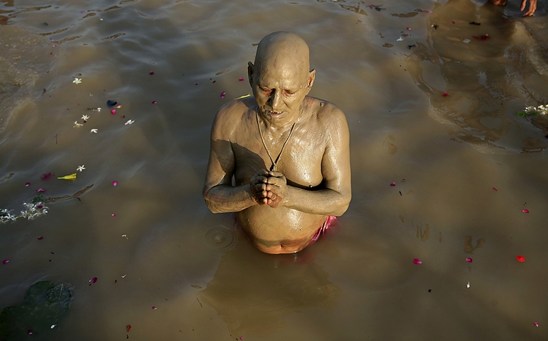 Индус выполняет Тарпан, ритуал, цель которого – упокой душ предков. Снимок сделан в Аллахабаде, Индия.