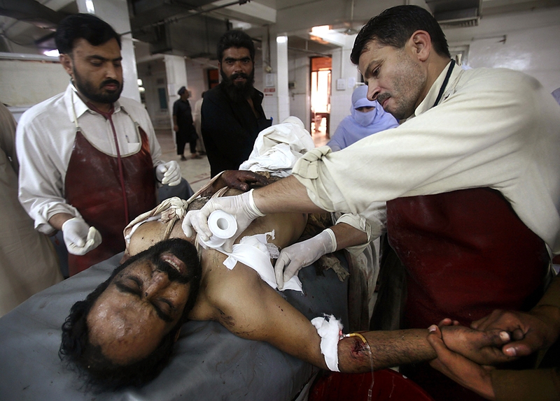 Персонал больницы в Пешаваре помогает одному из раненых во время атак террористов-смертников. В результате погибли, по меньшей мере, 29 человек и были уничтожены две гостиницы в пакистанском городе Кохат