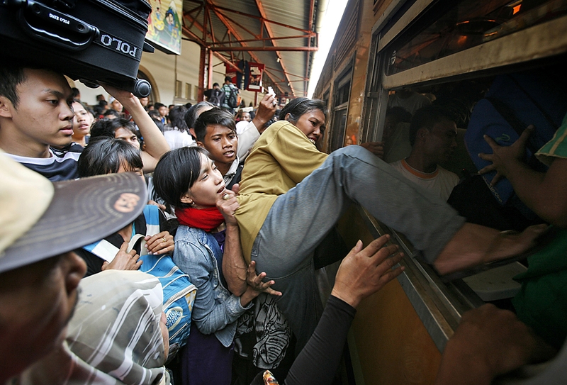 Индонезийские женщины залезают через окно в поезд, отправляющийся в Восточную Яву со станции Сенен в Джакарте, Индонезия. Миллионы людей в прошлую пятницу отправились из крупных городов в отчие дома, чтобы отпраздновать Ид аль-Фитр, который знаменует окончание священного месяца Рамадан