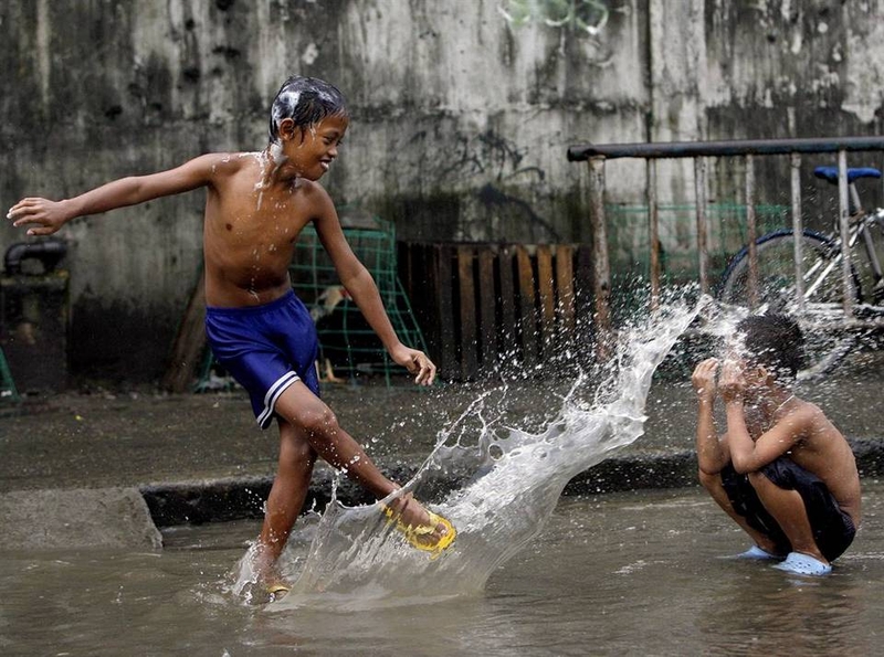 Филиппинские дети резвятся под дождем в районе трущоб в Кесон-Сити, восточная Манила на Филиппинах 11 сентября. Накануне по стране прошел тропический шторм Маринг. От наводнений и оползней, вызванных штормом погибли, по меньшей мере, 13 человек. Урожаю был нанесен значительный ущерб.