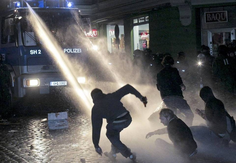 Полиция с помощью водометов разгоняет людей после уличного фестиваля Schanzenfest в Гамбурге ночью 13 сентября. Несколько сотен человек участвовали в столкновении с полицией после однодневного фестиваля, который прошел в районе печально известном своим противостоянием законности.