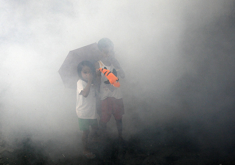 Дети затыкают носы, в то время как правительственные рабочие проводят дезинфекцию в трущобах Манилы. Президент Глория Арройо приказала принять меры по борьбе с распространением лихорадки денге. В соответствии с данными Департамента здравоохранения Филиппин, около 200 человек умерли в этом году в связи с лихорадкой денге.