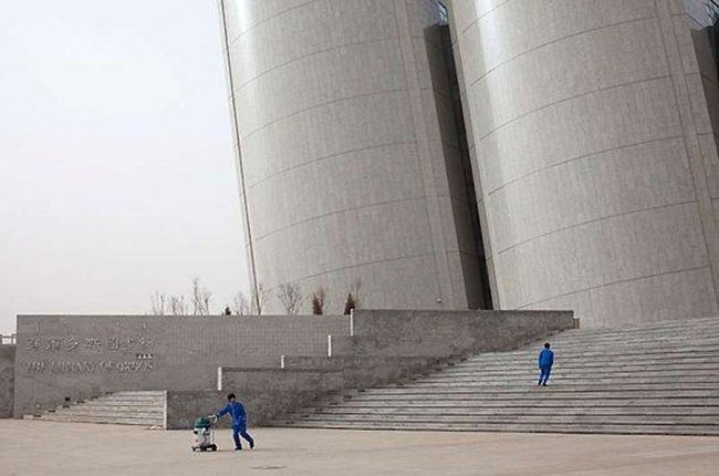 Двое рабочих убирают территорию вокруг здания публичной библиотеки. Доход на душу населения в Ордосе второй по величине в стране после Шанхая.