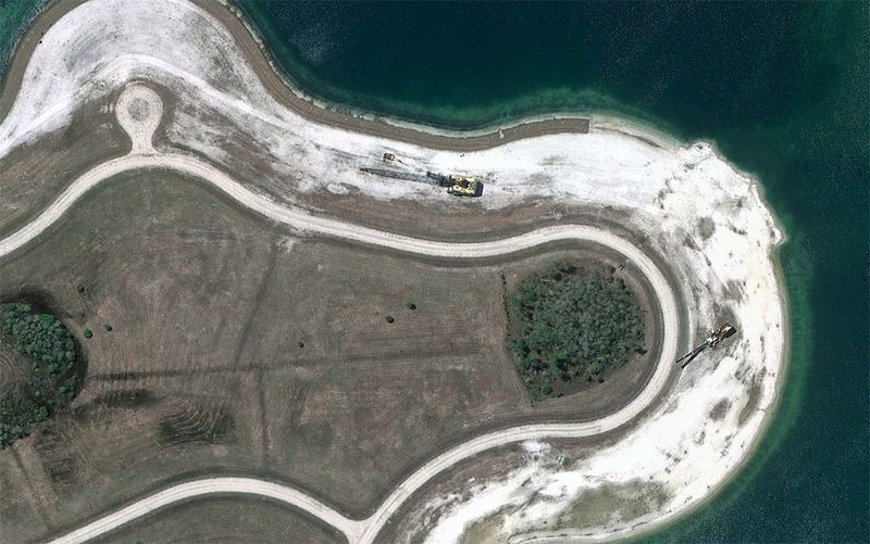 Строительная техника стоит у искусственного озера в юго-восточной части Форт Майерс, Флорида. (© Google)