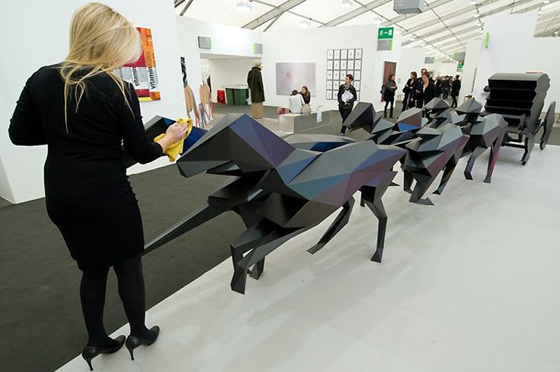 На ярмарке в этом году представлено рекордное количество галерей. На фото: Женщина стирает отпечатки пальцев с работы Ксавье Вейльяна “Le Carrosse”.