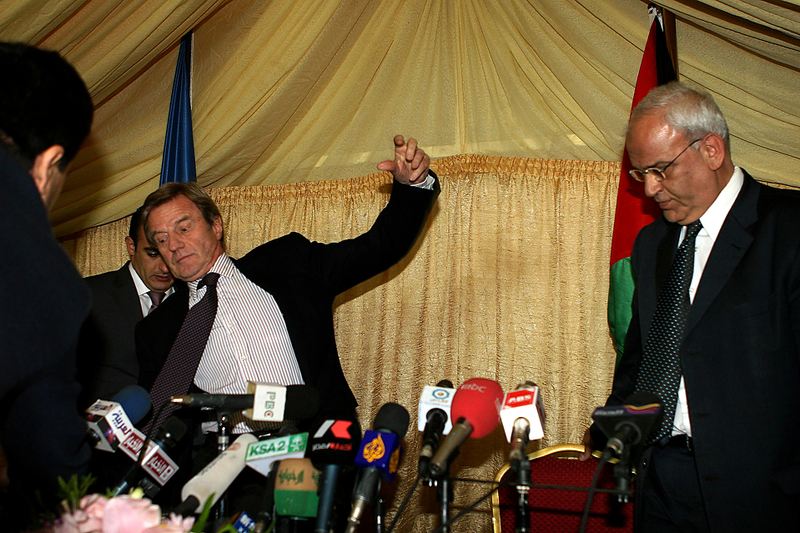 Министр иностранных дел Франции Бернар Кушнер поскользнулся во время пресс-конференции с начальником палестинской делегации Саибом Эрекатом, справа, в Аммане, Иордания. Кушнер призвал израильтян и палестинцев возобновить мирные переговоры.