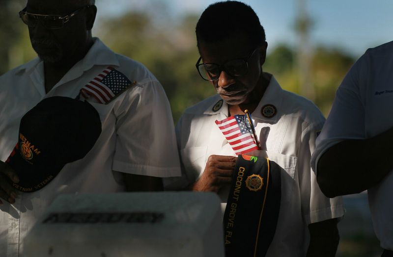 Ветеран армии США Джон Буллард и другие ветераны склонили головы в молитве во время церемонии в День Ветеранов br на кладбище в Коконат Гроув, штат Флорида. На этом кладбище похоронено немало ветеранов.