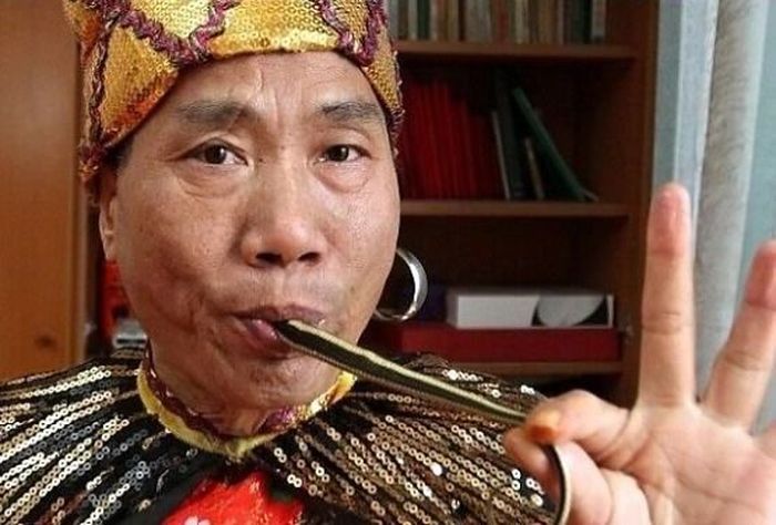 53-летний китаец может засовывать себе в нос по две змеи (3 фото)