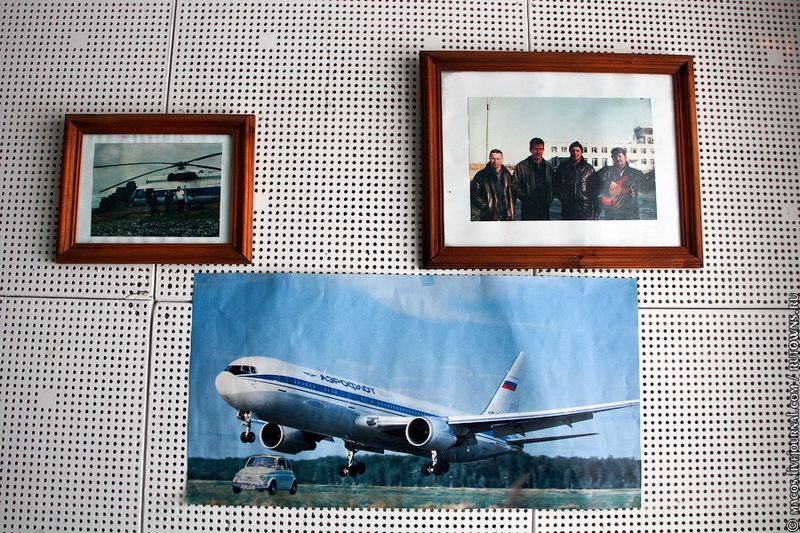 Рядом с ней - старые фотографии. Вот коллектив летал летом в Анапу. Вот пилоты на фоне родного аэропорта, еще работающего. А внизу плакат с Ту-154. Он уже с российским флагом, но еще советским логотипом. А какой-то шутник приклеил рядом картинку со старым Фиатом.